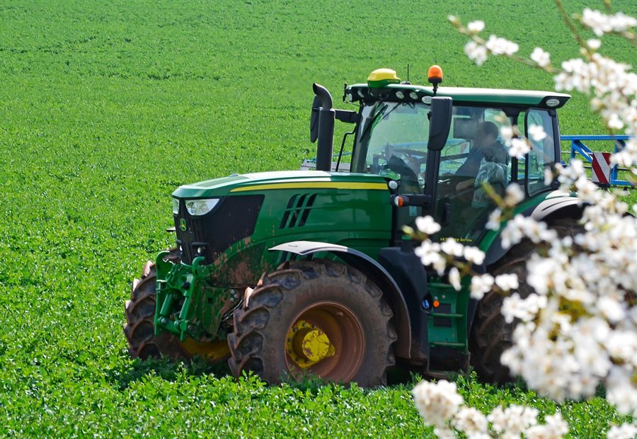 Precision agriculture — tractor working a green crop field